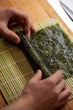 Şef maki suşisi pilav ve nori ile pişiriyor.