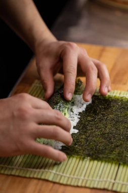 Şef maki suşisi pilav ve nori ile pişiriyor.