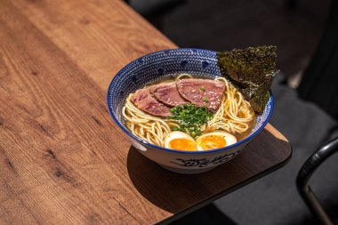 Kafe masasında sığır pastırmalı Japon ramen çorbası.