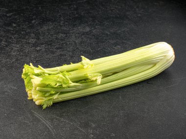 Gri arka planda taze yeşil kereviz çubukları