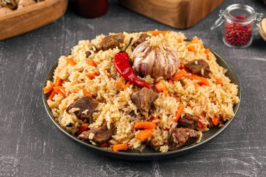 Özbek şenlik pilavı ile büyük tabak gri arkaplan üzerine plov
