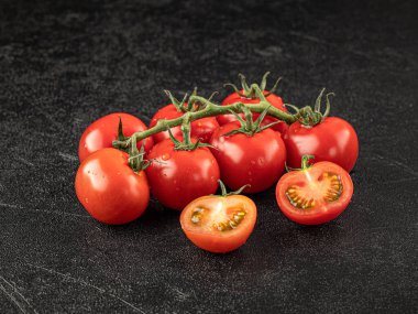 Gri arkaplanda taze kırmızı domates dalı