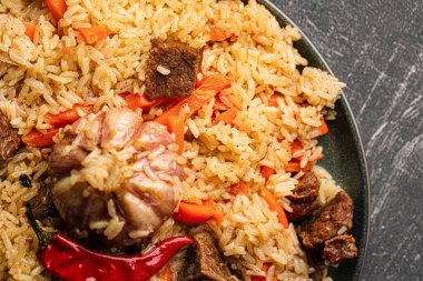 Özbek şenlik pilavı ile büyük tabak gri arkaplan üzerine plov