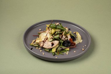 Yeşil arka planda elma ve avokado soslu tavuk salatası.