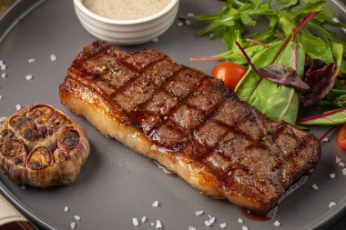 Sarımsaklı ve soslu ızgara bifteğe yakın çekim.