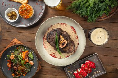 Ahşap masada biber soslu fırında sığır inciği.