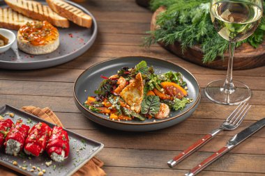 Porsiyon salata, hurma ve ahşap servis masasında karides.