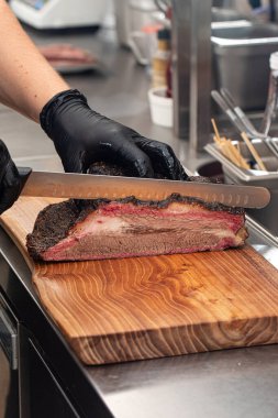 Şef mutfakta füme sığır eti dilimliyor.
