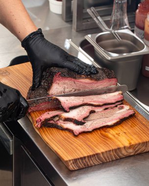 Şef mutfakta füme sığır eti dilimliyor.