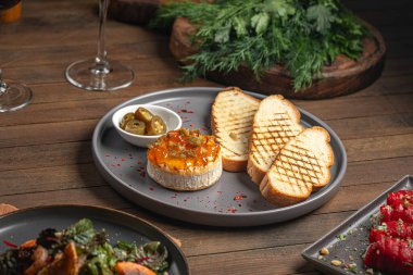 Jalapeno biberli fırında krem peynir ve ahşap masada tost.