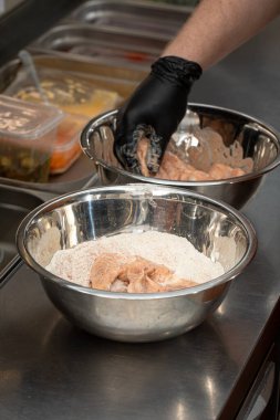 Şef kafeteryada kızarmış tavuk kanadı yapıyor.