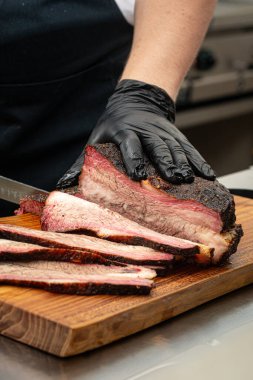 Şef mutfakta füme sığır eti dilimliyor.