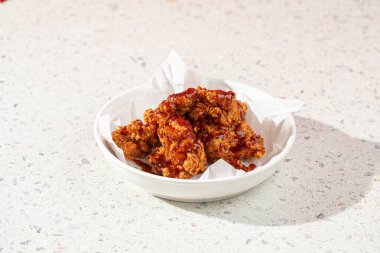 Bir porsiyon kızarmış kemiksiz kırmızı soslu tavuk budu.