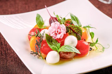 Bir porsiyon mozzarella soslu çeri domates salatası.