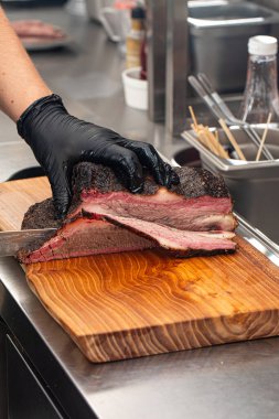 Şef mutfakta füme sığır eti dilimliyor.