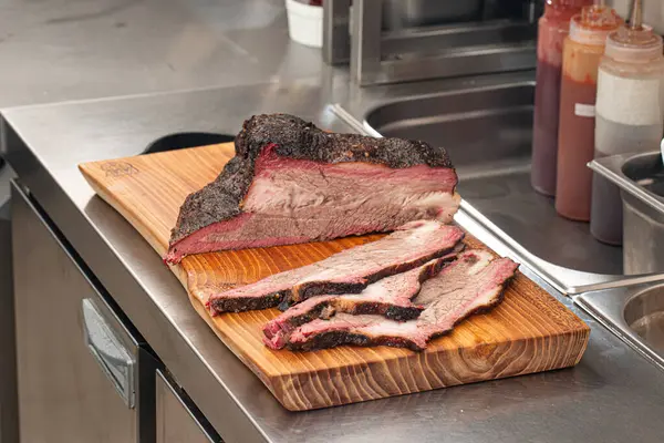 Dilimlenmiş Amerikan bifteği ahşap bir tahtanın üzerinde.