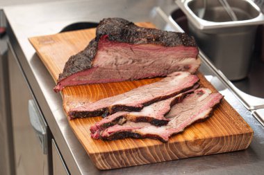 Dilimlenmiş Amerikan bifteği ahşap bir tahtanın üzerinde.