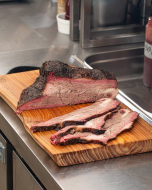 Dilimlenmiş Amerikan bifteği ahşap bir tahtanın üzerinde.