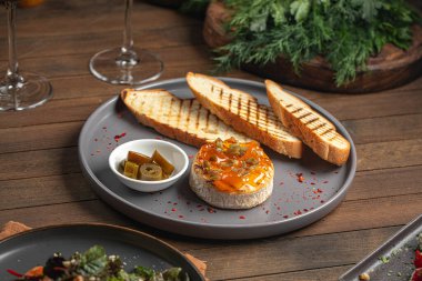 Jalapeno biberli fırında krem peynir ve ahşap masada tost.