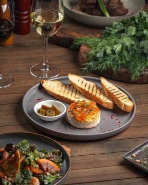 Jalapeno biberli fırında krem peynir ve ahşap masada tost.