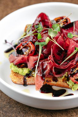 Avokado ve balzamik soslu gurme jambonlu tost.