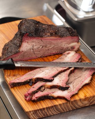 Dilimlenmiş Amerikan bifteği ahşap bir tahtanın üzerinde.