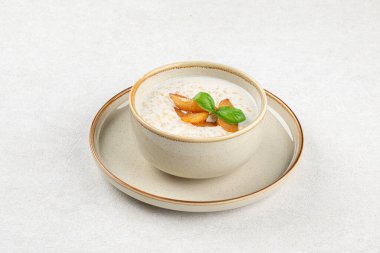 Bir porsiyon gurme kahvaltı lapası ve şeftali.