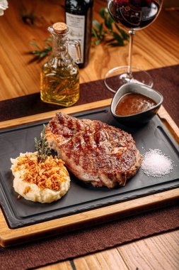 Izgara biftek, patates püresi ve kızarmış soğan.