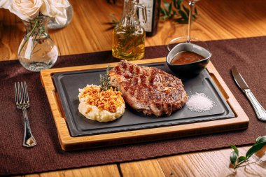 Izgara biftek, patates püresi ve kızarmış soğan.