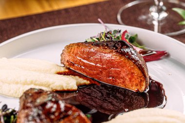 Bir porsiyon ızgara biftek, patates püresi ve sos.