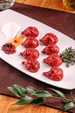 Bir porsiyon soslu gurme kırmızı renkli hamur köftesi.