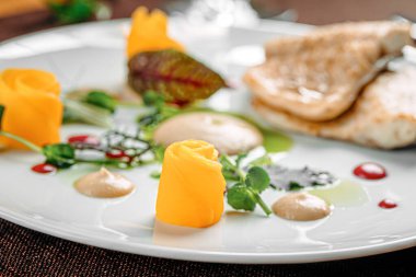 Meyve dilimleri ve soslu gurme beyaz balık tabağı.