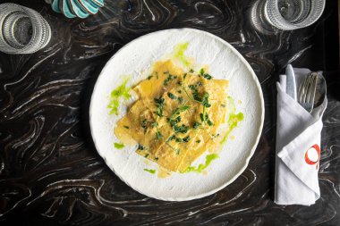 Soslu ve yeşil yağlı İtalyan mantısı.