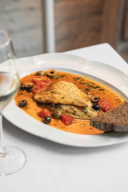 Puttanesca soslu gurme dorado balığı ve şarap.