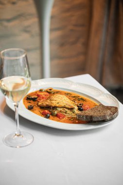 Puttanesca soslu gurme dorado balığı ve şarap.