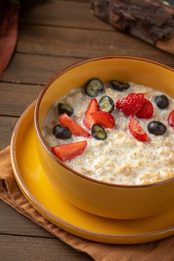 Tahta arka planda böğürtlenli yulaf lapası.