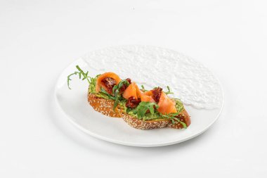 Bir tabak somon ve kurutulmuş domatesli gurme bruschetta.