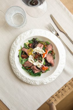 Stracciatella ve domatesli biftek salatası.