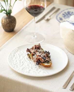 Rosto, biftek ve beyaz tabakta yeşil şarap.