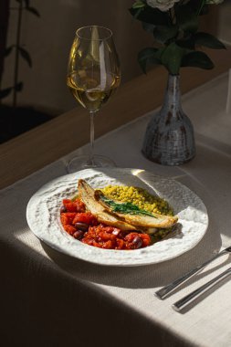 Pişmiş levrek fileto, ptitim domates ve şaraplı zeytin.