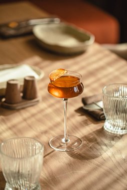 Tahta masada narenciye garnitürlü zarif kehribar kokteyli.