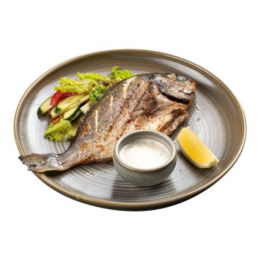 Izgara Dorado balığı salata ve sosla servis edilir.