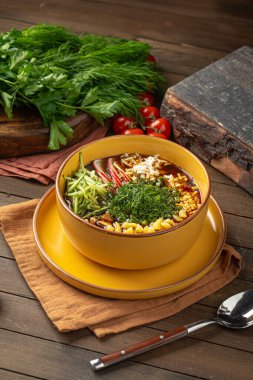 Kvass sebzeli Okroshka çorbası ve sarı kasede otlar.