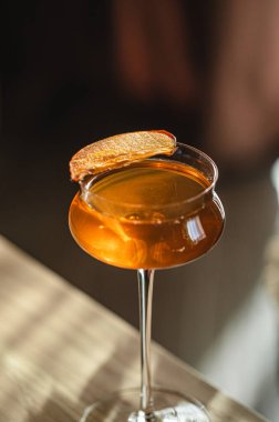 Tahta masada narenciye garnitürlü zarif kehribar kokteyli.