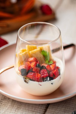 Böğürtlenli, vanilyalı ve ahşap masada servis edilen waffle.