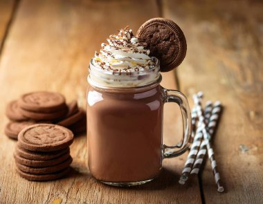 Chocolate milkshake topped with whipped cream, served in a glass mason jar with cookies on a (1) clipart