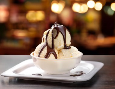 Vanilla ice cream with chocolate sauce on modern shop background, selective focus  (4) clipart