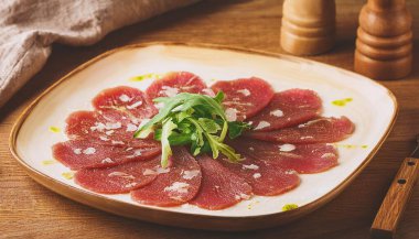 Italian Beef Carpaccio on a Classic Square Wooden Plate. Copy space photography style. clipart