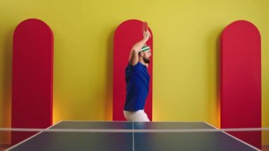 Masa tenisi ya da masa tenisi oynamaya başlamadan önce en sevdiği raketi tutarken kameranın önünde dans eden karizmatik bir adam. ARRI Alexa Mini 'de çekilen