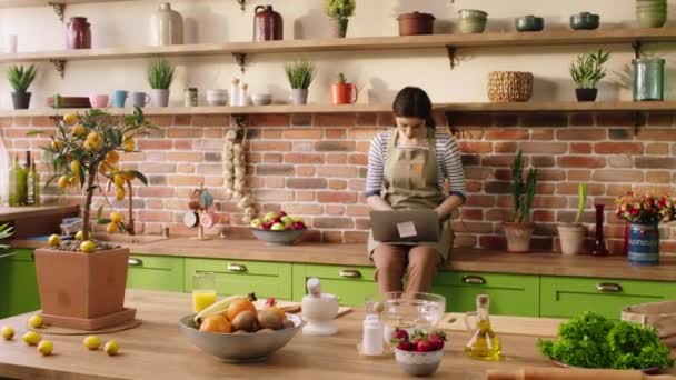 Cocina Mujer Feliz Mientras Sienta Sobre Mesa Cocina Que Utiliza — Vídeos de Stock